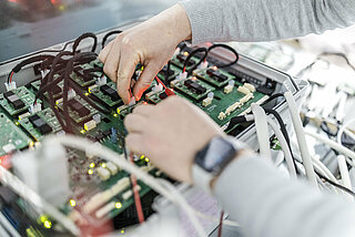 A man installs an INVENOX battery management system.