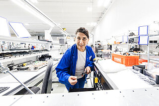 Frau mit Werkzeug in der Hand am Arbeitsplatz in Batteriesystemmontage von INVENOX.